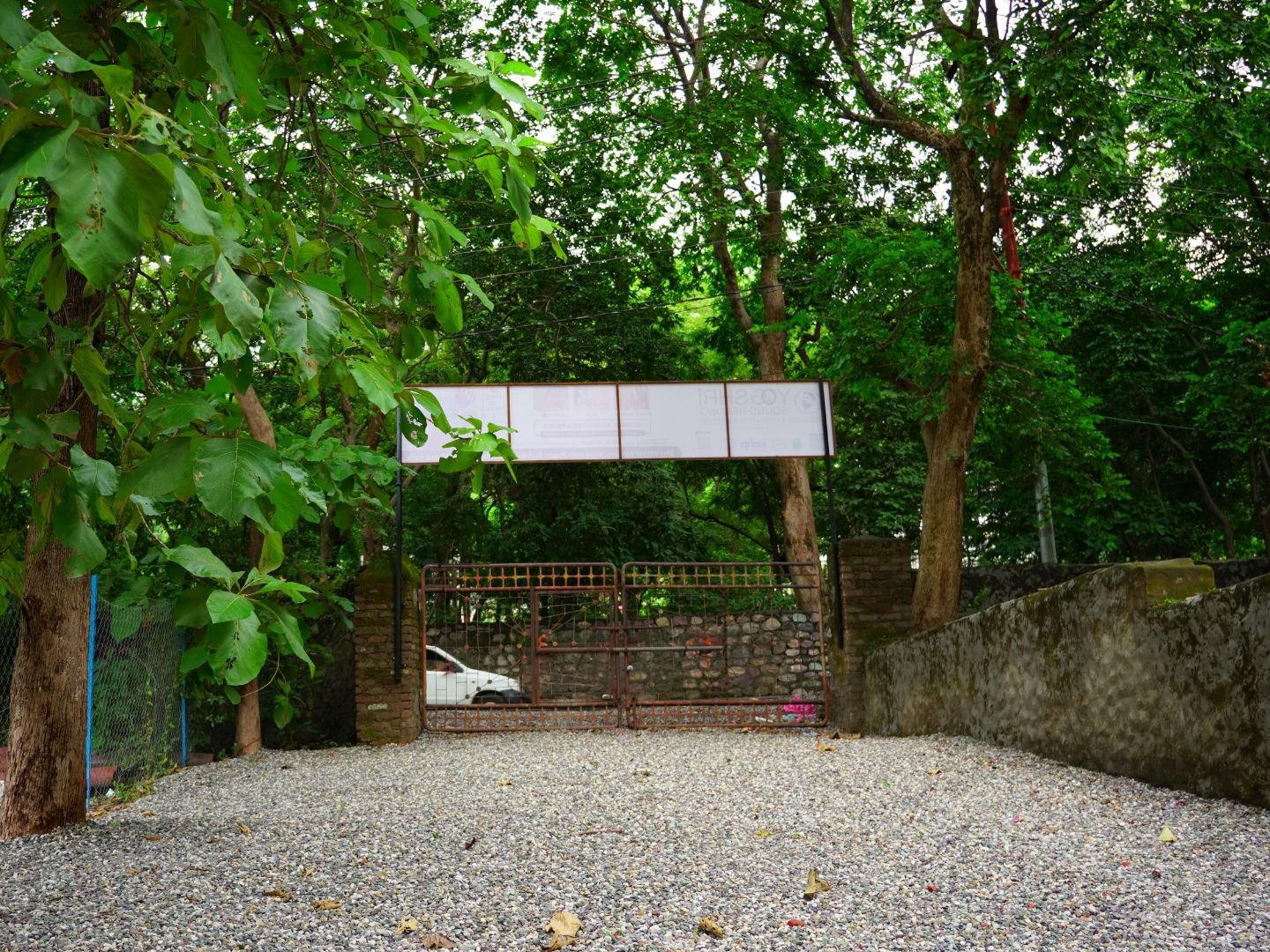 yogshri-ashram6 Ashram entrance surrounded by trees and greenery